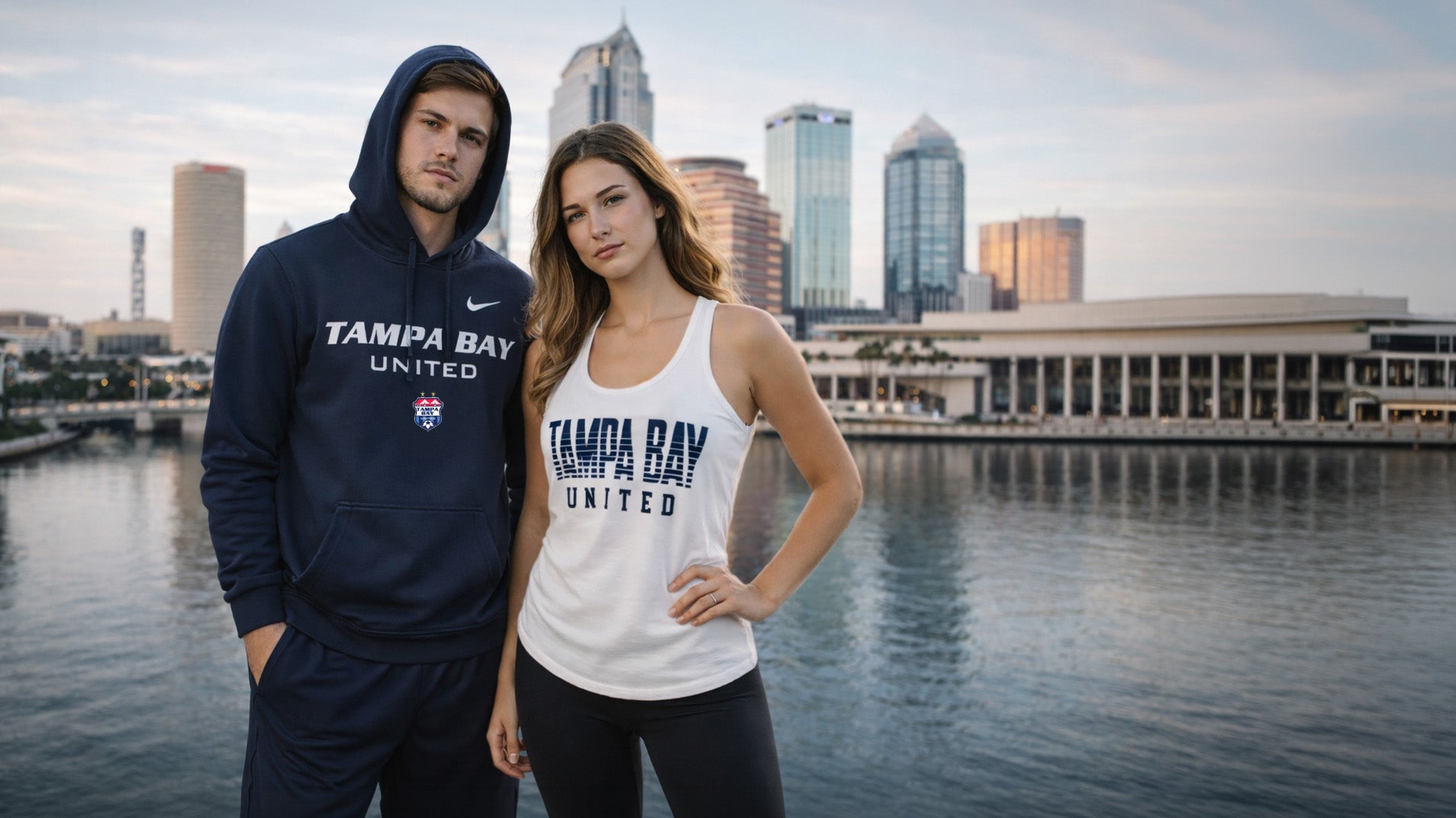 Two people wearing Tampa Bay United sports gear with a city skyline in the background.